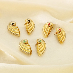 Detail of fan-shaped gold earrings with red, green and black stones on silk background