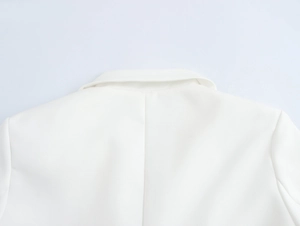 Detail of the white blazer collar and shoulder with a smooth structured finish