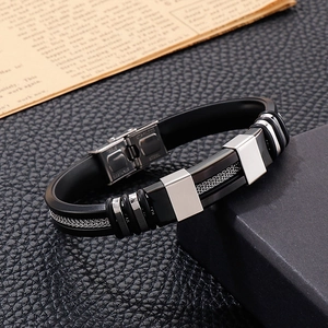 Detail of stainless steel clasp and braided metal inlay on black silicone bracelet