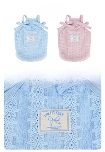 Détail de robe en dentelle pour animal avec motifs floraux, nœuds et étiquette brodée