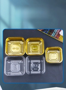Macro detail of food-grade square PET trays in gold and transparent plastic finishes