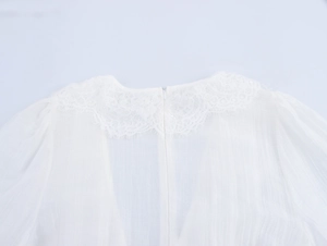 Détail d'une robe en mousseline blanche avec col en dentelle et zip invisible