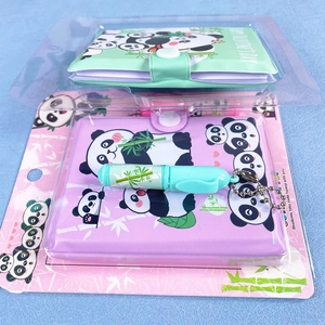 Detail von zwei Panda-Notizbüchern in Grün und Lila mit passenden Stiften und Druckknopf