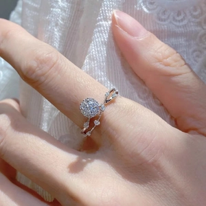 Silver moissanite engagement ring with twisted band and round center stone on lace