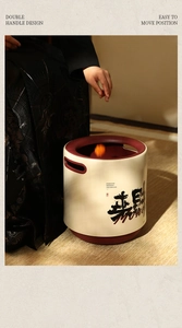 Detail of cream luxury trash bin with double handles and festive Chinese calligraphy art