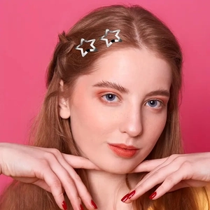 Silver star-shaped metal hair clips worn on hair for a stylish minimalist look