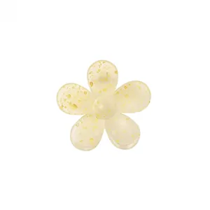 Detailed macro of translucent yellow floral hair claw with golden glitter highlights