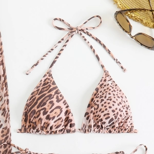 Flat lay of leopard print bikini top with side metal rings and tie-up halter straps