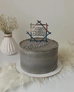Macro shot of metallic Happy Birthday cake topper in a hollow hexagonal acrylic frame