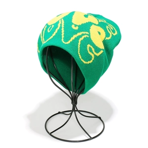 Detailed knit texture of green beanie with yellow LOVE jacquard on wire frame display
