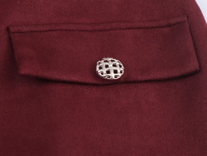 Détail du tissu en tweed rouge avec un bouton métallique tissé sur le rabat de poche