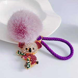 Cute purple crystal koala keychain with fluffy fur pompom and woven leather strap