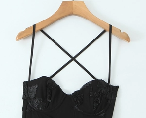 Close-up of black bodycon dress with 3D floral appliques and delicate thin straps