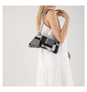 Detail of irregular geometric shoulder bag with metallic chain and color-block texture
