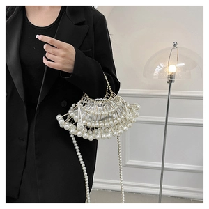 Close-up of pearl evening bag featuring a metal frame and beaded shoulder strap