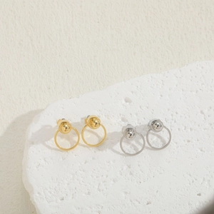 Minimalist gold and silver geometric ball hoop earrings on a textured stone surface