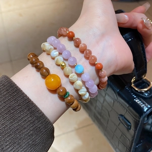Detail of four-piece layered beaded bracelet set with natural stones on wrist