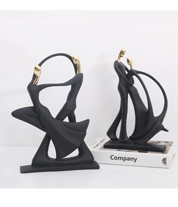 Detail of minimalist black and gold abstract music dance figurines on a white book