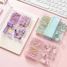Flat lay of macaron-colored stationery set with paper clips and binder clips in storage boxes