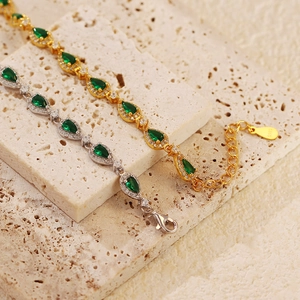 Macro detail of emerald drop bracelets in gold and silver with S925 hallmark