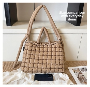 Close-up of khaki quilted tote bag showing large capacity with phone for scale