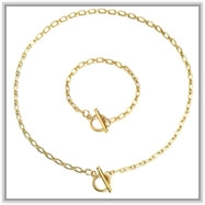 Detail of golden box chain jewelry set featuring floral accents and toggle clasps