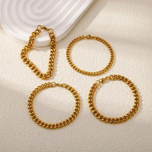 Detailed view of four golden curb chains in varying thickness with lobster clasps
