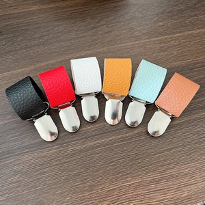 Clip per cappelli in pelle PU per bagagli in sei colori su sfondo di legno scuro