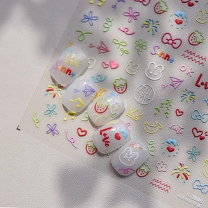 Macro view of embossed nail stickers featuring colorful cute lines and rainbow motifs