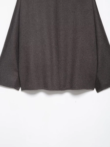Detailed close-up showing the charcoal grey wool texture and hem of the jacket