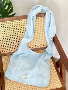 Schultertasche aus Chiffon mit Blumenstickerei, Perlenriemen und Fransen am Holzstuhl