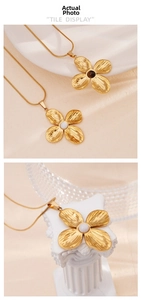 Detailed close-up of gold petal pendant necklace with pearl and onyx inlay details