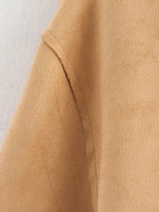 Detailed close-up showing the precise stitching and texture of tan faux suede jacket fabric