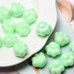 Detailed view of green acrylic cat paw beads for DIY jewelry and beaded crafts