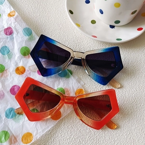 Oversized butterfly cat-eye sunglasses in blue and orange gradient on a white surface