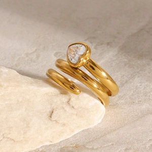 Macro shot of gold heart-shaped zircon ring with spiral design on textured stone