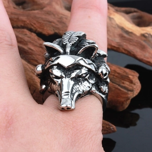 Gros plan d'une bague tête de loup argentée vintage avec détails punk et plumes