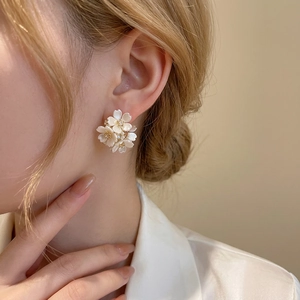 Eleganti orecchini a cerchio a C con fiori bianchi e diamanti indossati dal modello