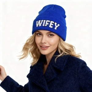 Détail du bonnet en maille bleu roi avec broderie WIFEY blanche et texture douce