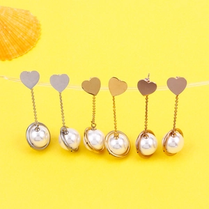 Star heart pearl drop earrings in gold and silver finish on yellow background