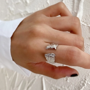 Detail of silver S925 ring with irregular lava texture worn on female finger