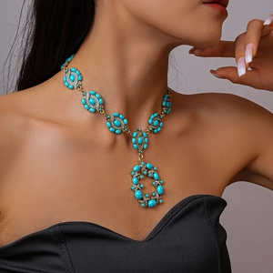 Détail d'un collier vintage avec pierres turquoises et strass porté par un mannequin