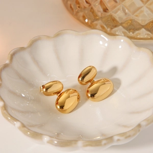 Orecchini a perno ovali minimalisti in oro 18 carati in acciaio lucido su piatto ceramico