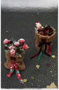 Detail of plush bear Christmas flower packaging with red roses and pine cones