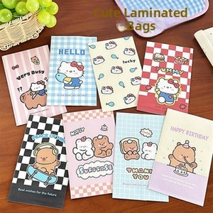 Detail view of cute cartoon cat and bear patterned packaging bags on wooden tabletop