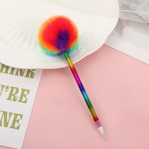 Rainbow fluffy pom pom ball pen with gradient metal barrel on a pink decorative plate