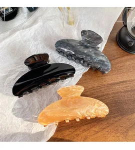 Detailed set of three colorful acrylic hair claws in black, marble gray and amber champagne
