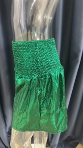 Detail of green metallic high waisted shorts with elastic pleated waistband design