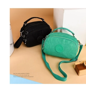 Nylon crossbody bags in black and mint green with multi-zipper layers and woven straps