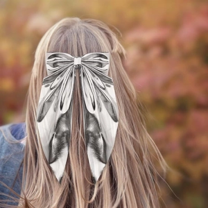 Elegant silver metallic bow hair clip styled on blonde hair with autumn background